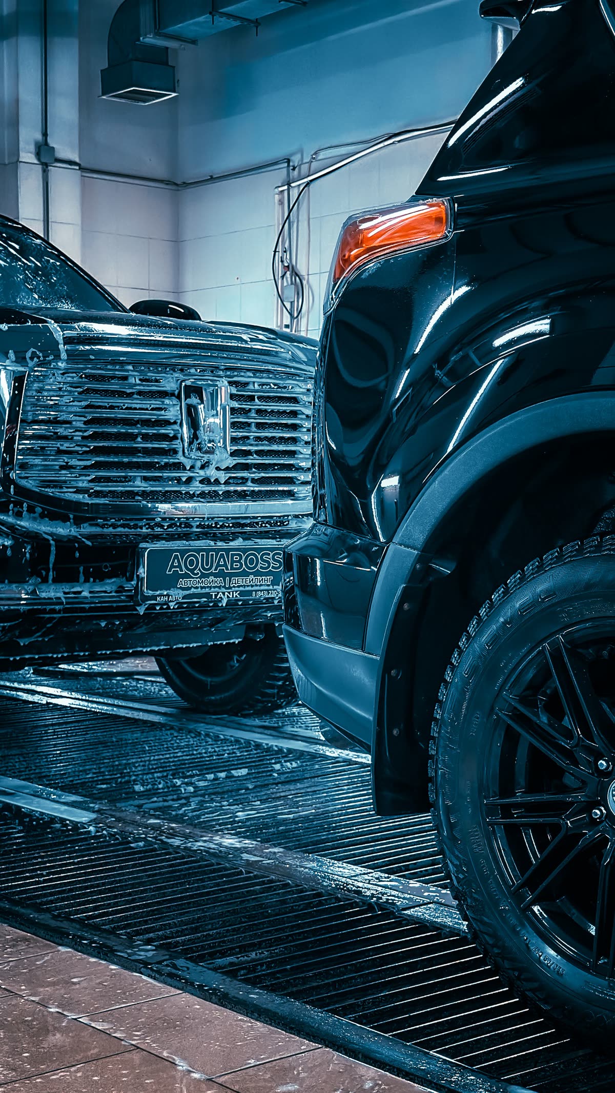 Luxury vehicles being washed in a professional indoor facility